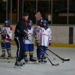 Coach en spelers op de Ijshockeybaan